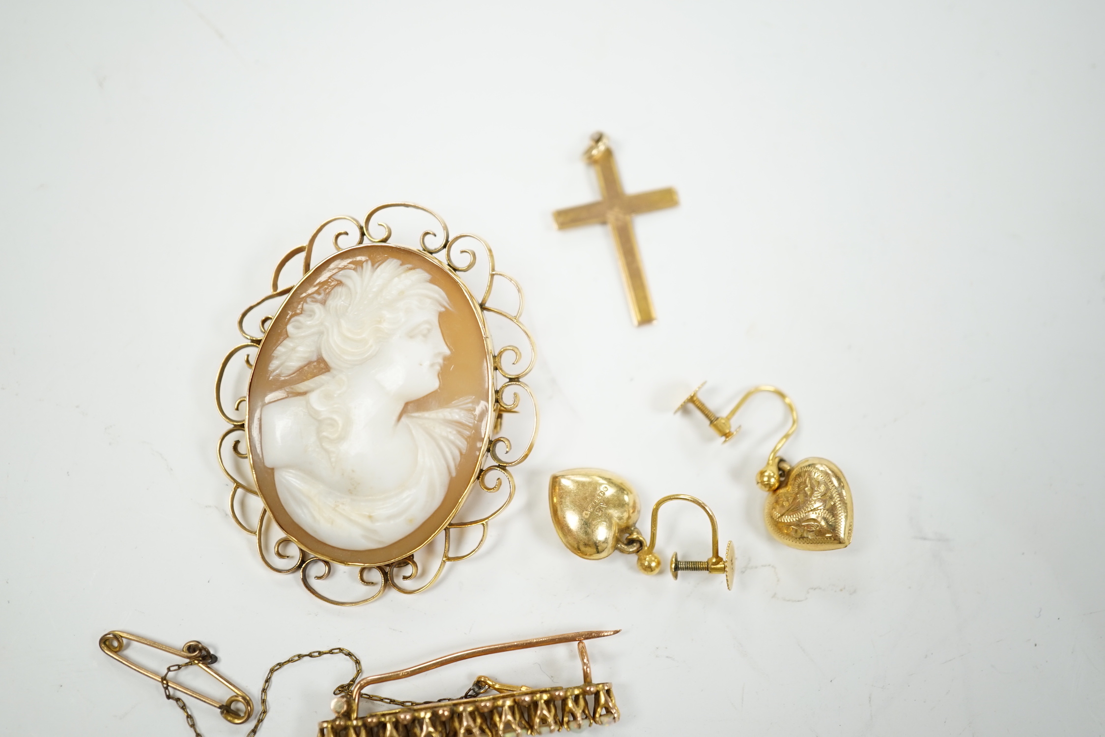 A 9ct and white opal cluster set bar brooch, a 9ct mounted oval cameo shell brooch, a pair of 9ct gold heart shaped drop earrings and a 9ct cross pendant, gross weight 13.4 grams.